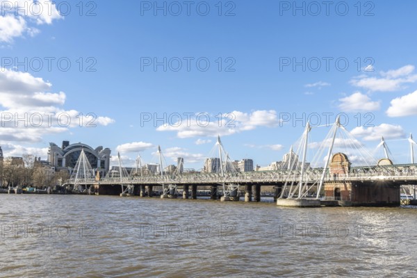 Modern pedestrian golden jubilee bridges flanking the railway hungerford bridge over the river