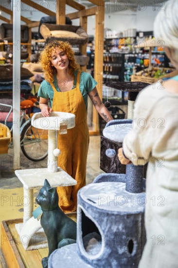 Saleswoman engaging with a customer while presenting various cat scratching posts inside a pet