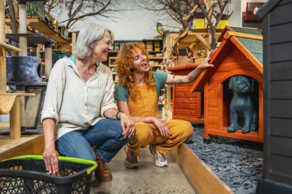 Smiling saleswoman showing a wooden dog house with a dog statue inside to a customer holding a
