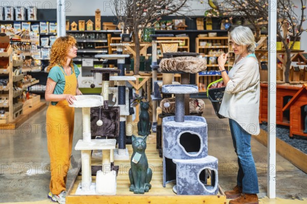 Pet shop assistant displaying various cat trees while helping a customer select the perfect