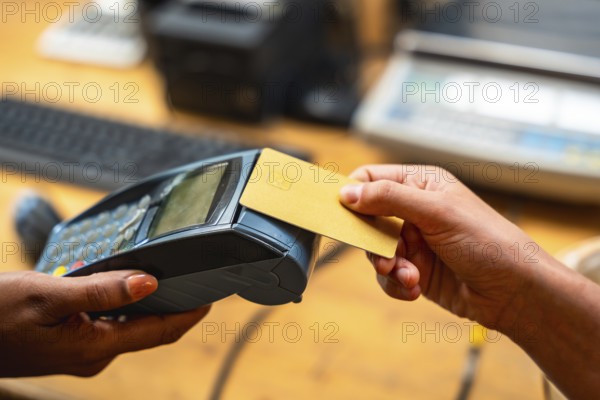 Customer making a purchase using a credit card on a point of sale terminal, highlighting modern