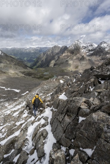 Mountaineer in rocky mountain landscape, at the summit of Keeskopf, behind summit of Petzeck, Hoher