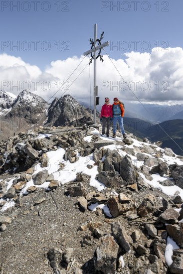 Two female mountaineers on the summit of the Keeskopf with summit cross, behind them summit of the