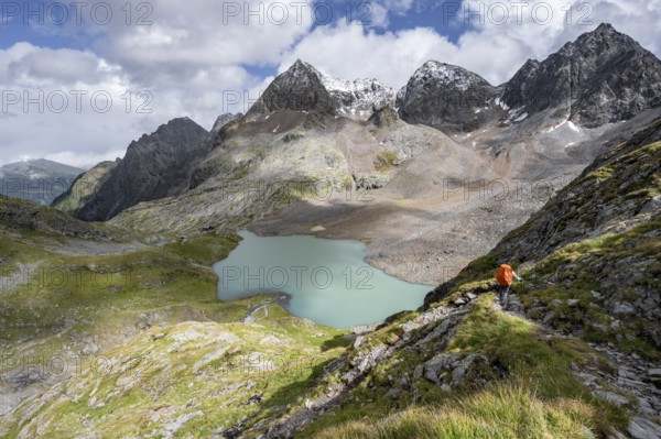 Mountaineer on hiking trail, view of turquoise-blue mountain lake Großer Gradensee, behind summit