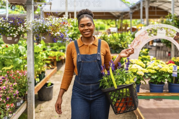 Young woman working at a garden center, happily carrying a basket brimming with vibrant flowers and