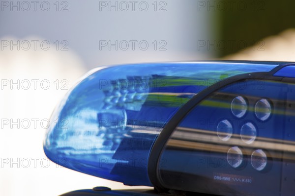 Symbolic image of a police operation: close-up of a flashing blue light on a police car