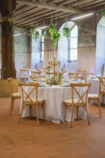Atmospheric wedding room with round tables and subtle light decorations, event and wedding location