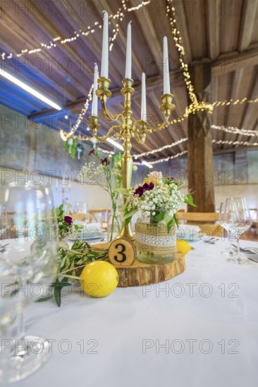 Detailed table decoration with candlestick and licence plate, surrounded by fresh flowers, event
