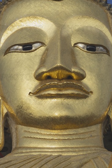 Face of a 32 metre high standing Buddha decorated with glass mosaics and 24-carat gold, Luang Pho