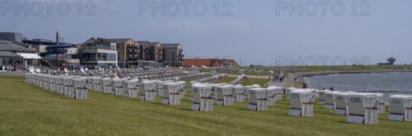 Beach chairs on the green beach, building on the promenade, Büsum, North Sea, Schleswig-Holstein,