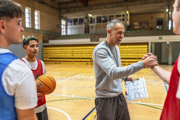Basketball coach shaking hands with a player and congratulating him after a training session in a