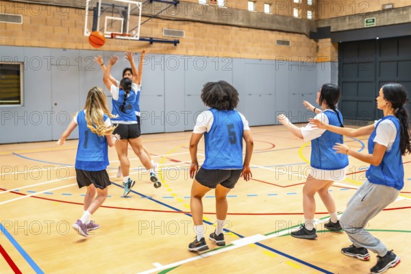 Group of young female athletes competing in a basketball match, showcasing their skills and