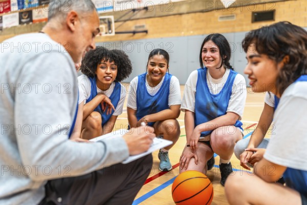 Basketball coach briefing his female team during a time out, taking notes and discussing game