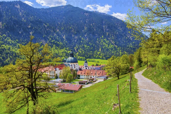 Hiking trail with Ettal Monastery in spring, municipality of Ettal, Ammergau Alps, Upper Bavaria,