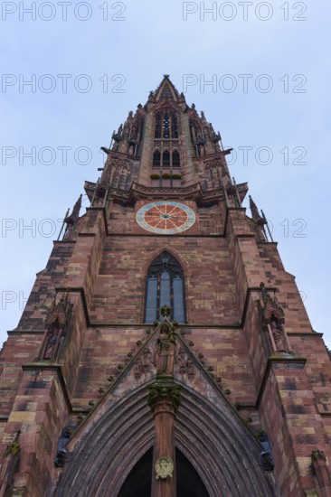Freiburg Minster, Gothic church tower made of red stone with sculptures and a clock, Freiburg im