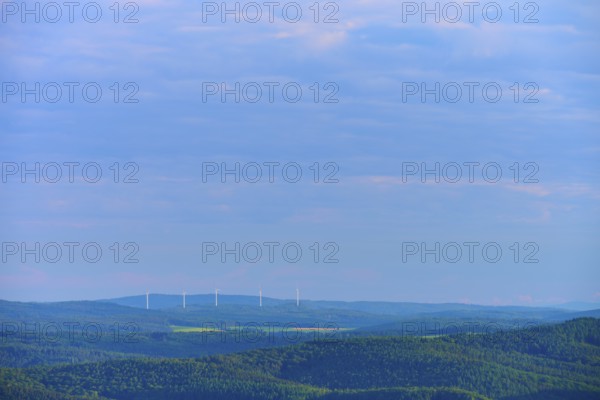 Hilly landscape with clouds, wind turbines on the horizon under a blue sky, Katzenbuckel,