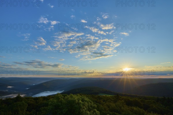Morning sun over a vast forest landscape, clear sky with some clouds, Katzenbuckel, Waldbrunn,