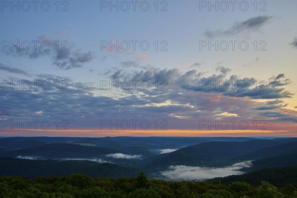 Wide mountain landscape at sunrise, sky covered by clouds in soft colours, Katzenbuckel, Waldbrunn,