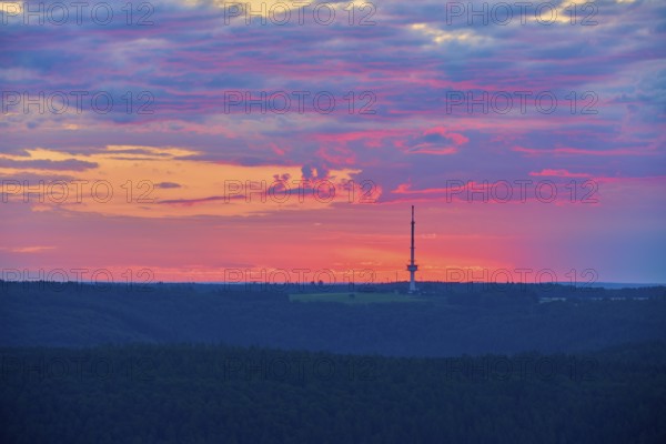 Dramatic sunrise on the horizon with a transmission mast, transmitter Reisenbach, as silhouette,