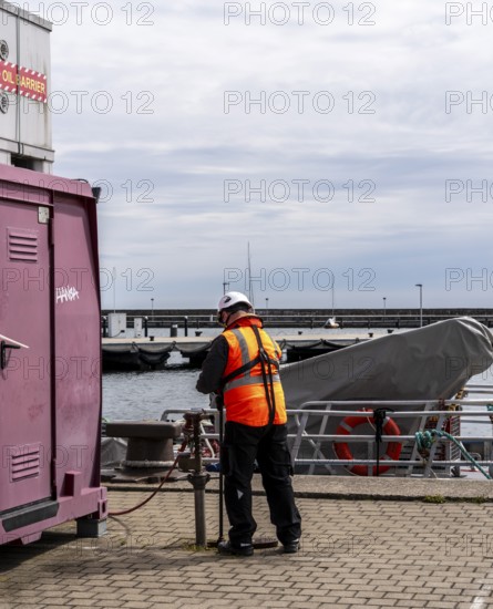 Worker with safety waistcoat in the city harbour of Sassnitz, Rügen, Mecklenburg-Vorpommern,