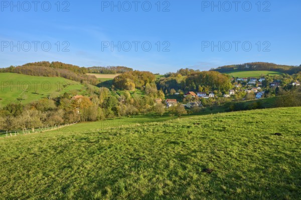 Small village embedded in green hills and trees, creating a harmonious landscape, Vöckelsbach,