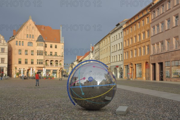 Historic houses with mood lighting on the market square, metal ball with reflection and inscription