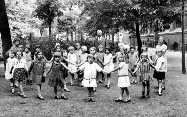 School class break Ringelreihen teacher, ca. 1920, Group of children with a teacher in the park