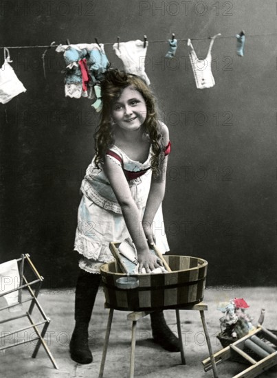 Girl at the washboard, 1920, Girl washing clothes in a wooden bucket, in the background more