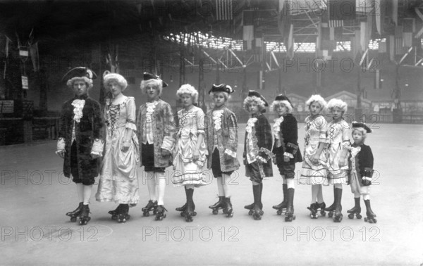 Group in historical costumes on roller skates from big to small, 1920, Group of children in