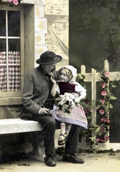 Costume, traditional dress, man and child in historical dress sitting on a bench outdoors,