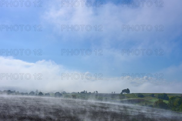 A wide landscape with fog, blue sky and trees in the distance, Schmachtenberg, Miltenberg,