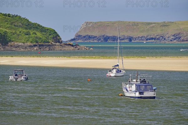 Boats on a river with green hills and rocky coast in the background, tides, Camel Trail, Padstow,