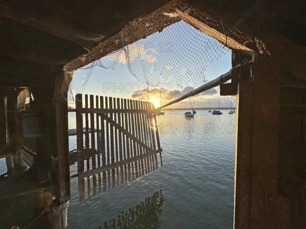 View from a boathouse onto Lake Starnberg at sunset, Bavaria, Germany