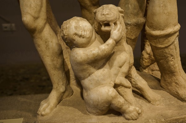 Close-up of an ancient marble sculpture of a child embracing a panther, Panther and Cupid,