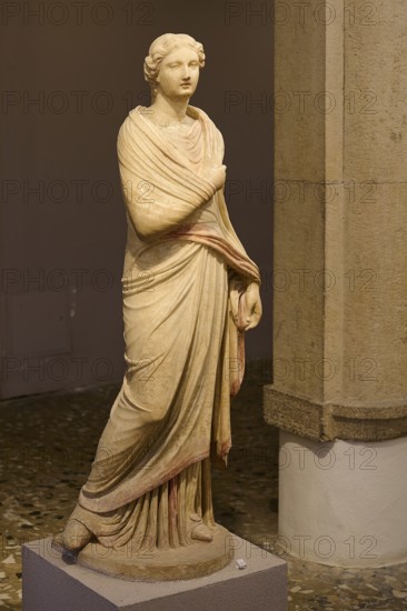 Ancient marble sculpture of a classical woman in a draped robe in the museum, Archaeological