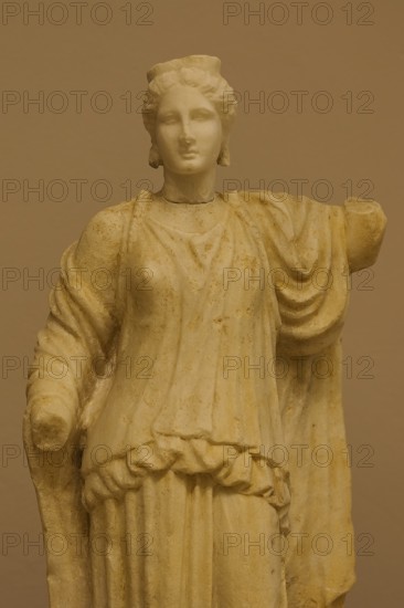 Marble statue of an ancient woman in classical dress, on display in a museum, Archaeological