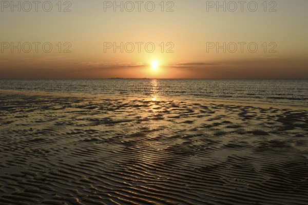 Sunset over the Wadden Sea on the German North Sea coast, typical ripple mudflats at low tide,