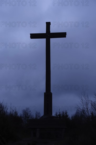 Cross against the dark sky, summit cross in the dark, mystical atmosphere of an approaching