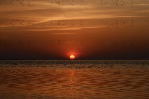 Fireball... Cuxhaven (North Sea), glowing red, setting sun, sunset over the Wadden Sea near Duhnen,