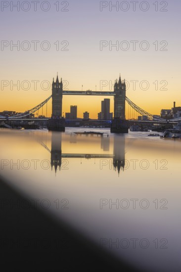 Famous bridge at sunset with reflection in the river and skyline in the background, London, United