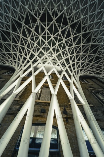 Futuristic geometric ceiling pattern with white pillars in modern architecture, King's Cross
