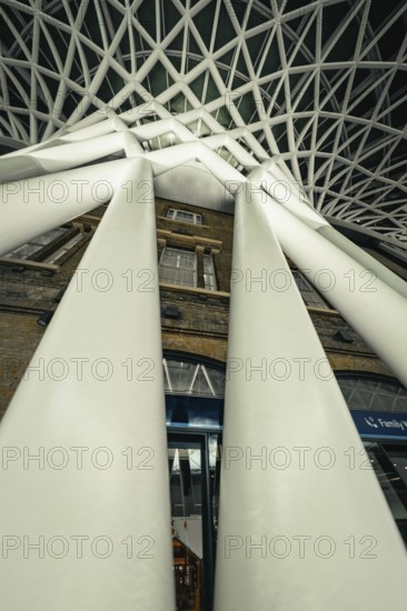 Dramatic perspective of huge white pillars under a modern glass roof, King's Cross Station, London,