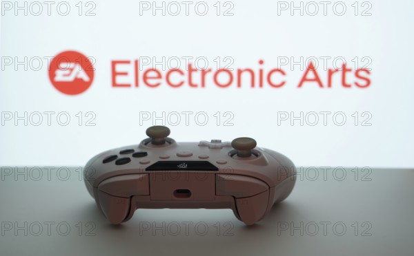 Dhaka, Bangladesh- 08 Apr 2025: A gaming controller in front of a Electronic Arts screen