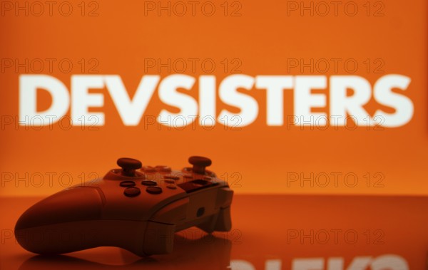 Dhaka, Bangladesh- 20 Mar 2025: A close-up of a white gamepad with the Devsisters seen on screen in