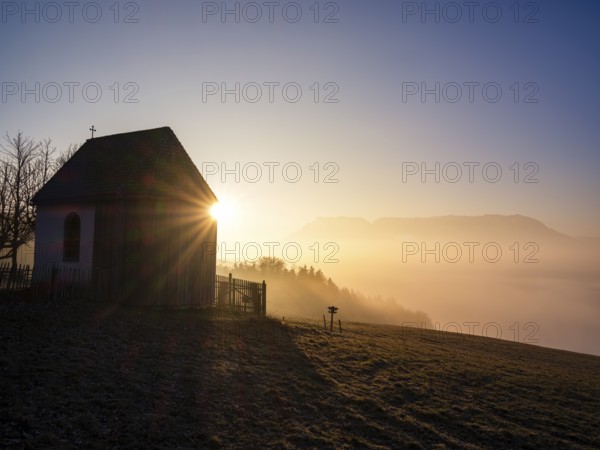 Sunbeams at a chapel above high fog at sunrise, Untersberg in the background, Högl, Anger,