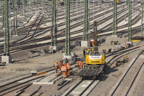 Team of workers works on rails using construction machinery at a large plant, Untertürkheim parking