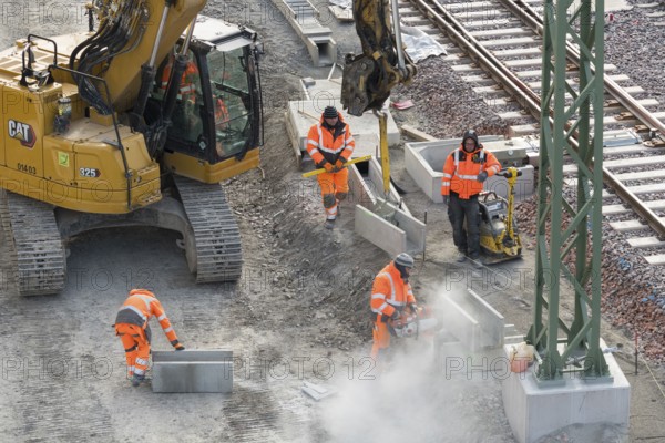 Construction workers use construction machinery to lay rail structures, cutters, vibrators,