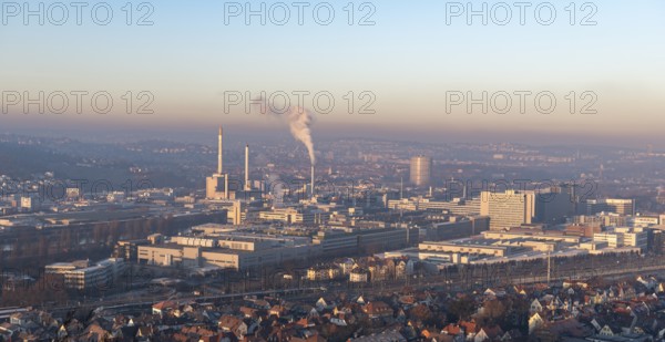 Extensive city view at sunrise with industrial plants and smoke developments, view of Daimler Group