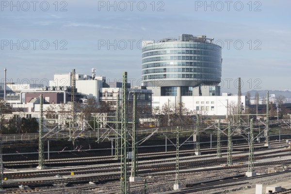 Modern building in an industrial area with railroad tracks in the foreground under clear skies,