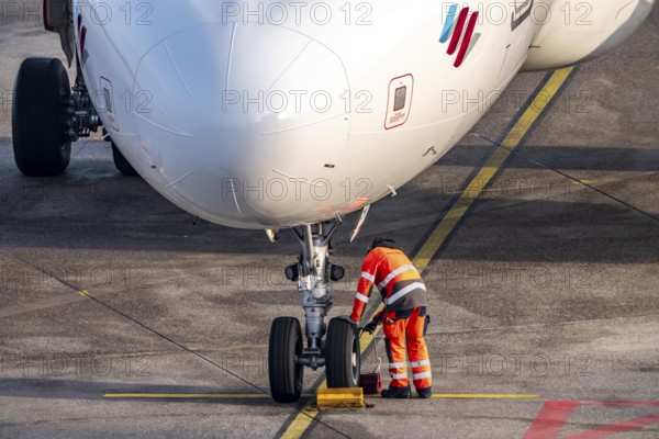 Ground crew positions brake blocks on the chassis, after stopping at the parking position, at the
